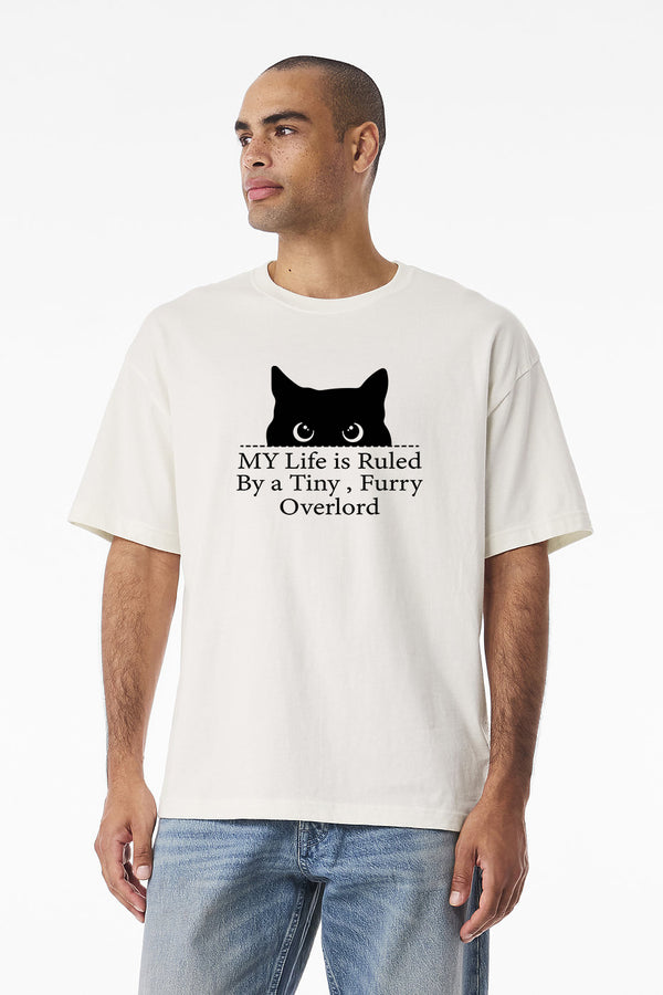 A man wears the Tiny Furry Overlord vintage white pet t-shirt with a black cat graphic and funny text—ideal for any proud pet lover.