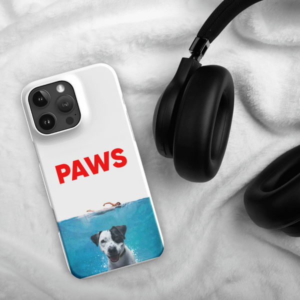 The Custom Pet iPhone Case – Paws Movie, featuring a dog swimming underwater, is displayed beside black headphones on a soft white fabric background.