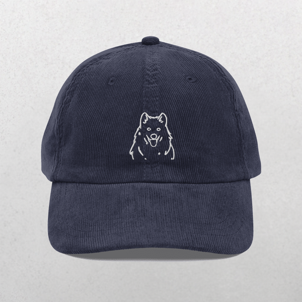 A navy Custom Pet Line Art Portrait Corduroy Cap – Embroidered Pet Hat, featuring a simple white embroidered outline of a dog’s face on the front, shown against a light gray textured background.