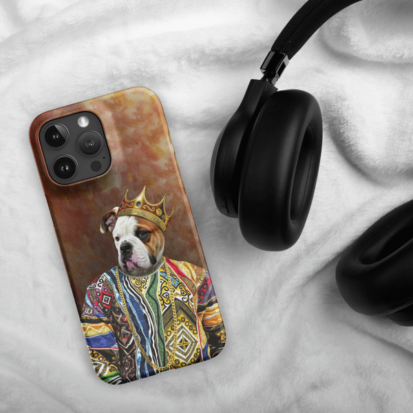 A Custom Pet iPhone Case – Notorious D.O.G., with a crowned bulldog in a colorful robe, rests beside black headphones on soft white fabric.