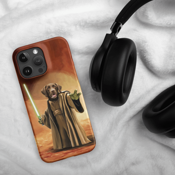 A Custom Pet iPhone Case – Star Wars, showing a dog as a Jedi with a green lightsaber, is placed beside black headphones on white fabric.