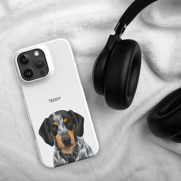 A Custom Pet iPhone Case – Modern Vector Art featuring an illustrated dog and the name TEDDY sits beside black headphones on a soft white blanket—an ideal gift for pet lovers.
