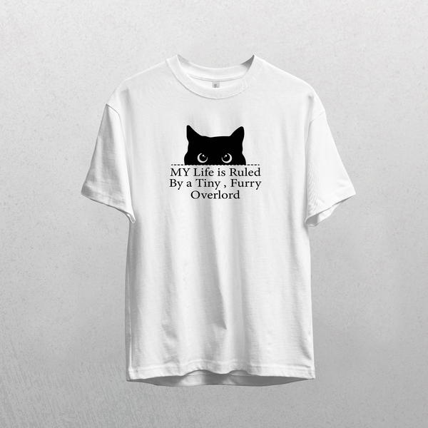 The Tiny Furry Overlord white t-shirt features a black cat head silhouette and the text MY Life is Ruled By a Tiny, Furry Overlord. A unique cat lover gift, shown on a light gray background.