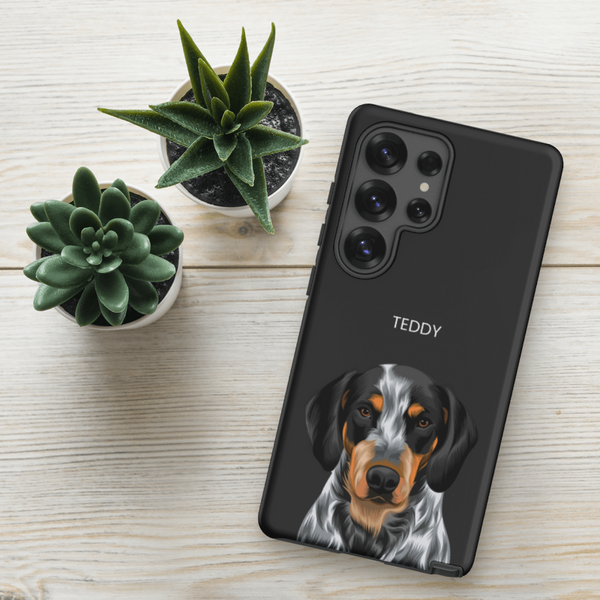 A black Samsung phone in a Custom Pet Samsung Case – Moder Pet Vector, showcasing a realistic dog illustration and the name TEDDY, rests on a light wood surface beside two small succulents—a unique keepsake for pet lovers.