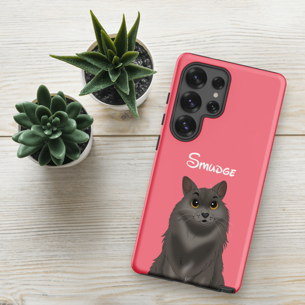 A Custom Pet Samsung Case – Disney in pink, featuring a fluffy gray cat illustration and Smudge in white text, lies on wood next to two small potted succulents—a unique keepsake for any cat lover.