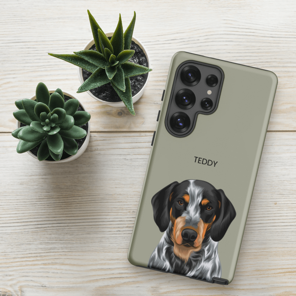 A Custom Pet Samsung Case – Moder Pet Vector displaying an illustrated dog and the name TEDDY rests on a light wooden surface beside two small potted succulents.