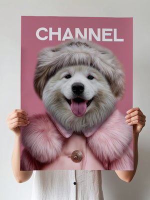 A person holds a Chanel Fashion Cover poster featuring pet artwork of a fluffy white dog in a pink coat and hat, set against a pink background with the word CHANNEL at the top, resembling a fashion magazine cover.