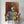 A person holds Notorious D.O.G., a vibrant custom pet portrait of a bulldog in a gold crown and patterned sweater, perfect as pet lover gift decor against a warm, abstract background.
