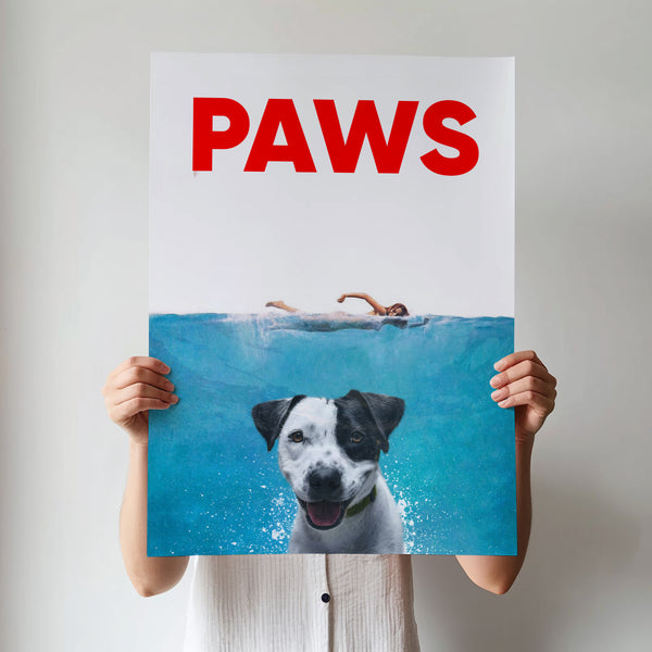 A person holds the Paws Film Cover: a playful poster featuring a swimmer above and a happy dog underwater, mimicking the Jaws movie poster. PAWS stands bold in red—a unique, personalized canvas for any pet lover.