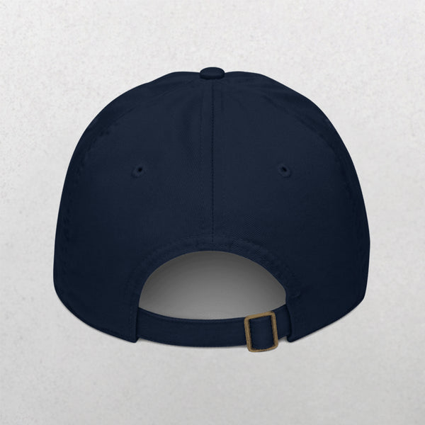 The Embroidered Pet Portrait Organic Classic Dad Cap in navy blue is shown from the back, highlighting its adjustable strap with brass buckle against a plain light background.