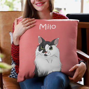 A woman in a red patterned top and blue jeans smiles while holding a Custom Disney Pet Cushion—a pink pillow featuring an illustrated black and white cat named Milo—showing off this cozy, personalized pet keepsake.