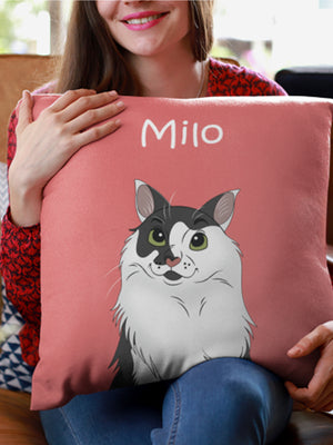 A woman in a red patterned top and blue jeans smiles while holding a Custom Disney Pet Cushion—a pink pillow featuring an illustrated black and white cat named Milo—showing off this cozy, personalized pet keepsake.
