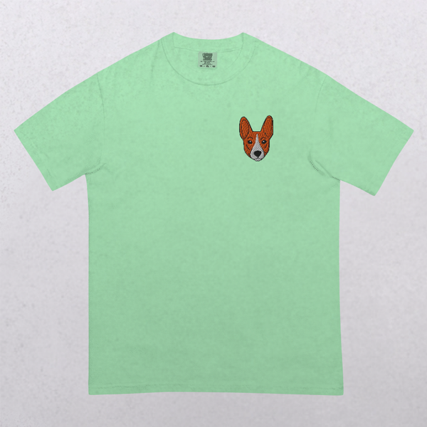 Embroidered Pet Portrait Organic T-Shirt in light green with a small corgi face stitched on the left chest—a charming vintage-style gift for pet lovers, set against a subtly textured background.