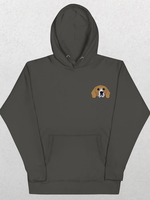 The Embroidered Custom Pet Hoodie in Charcol Heather features a small cartoon beagle face on the left chest—ideal as a cozy keepsake for animal lovers. Shown on a light gray textured surface.