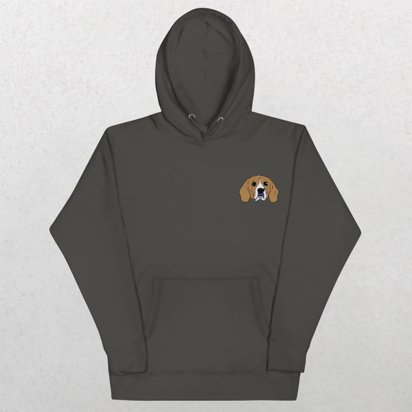 The Embroidered Custom Pet Hoodie in Charcol Heather features a small cartoon beagle face on the left chest—ideal as a cozy keepsake for animal lovers. Shown on a light gray textured surface.