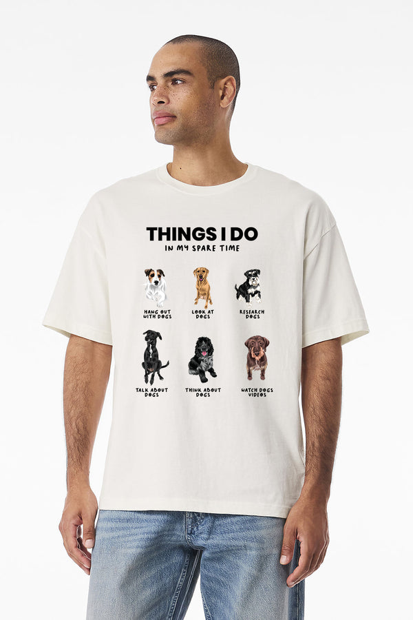 A man wears the “Things I Do In My Spare Time” white vintage pet t-shirt, featuring six dog images and funny pet lover activities—an ideal gift for dog lovers.