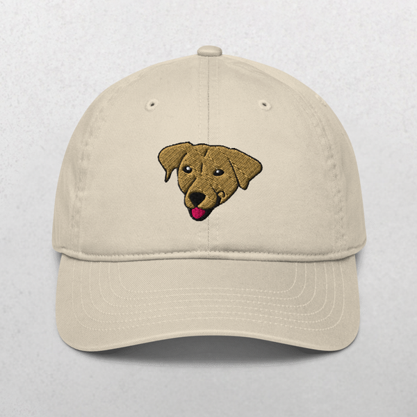 The Embroidered Pet Portrait Organic Classic Dad Cap in oyster features a brown dogs face with its tongue out, embroidered on the front—an ideal personalized pet gift for dog dads.