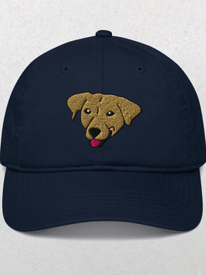 The Embroidered Pet Portrait Organic Classic Dad Cap in Pacific features an embroidered tan dog face with its tongue out, centered on the front. This unique cap is a perfect personalized pet keepsake or gift. Shown on a plain, light background.
