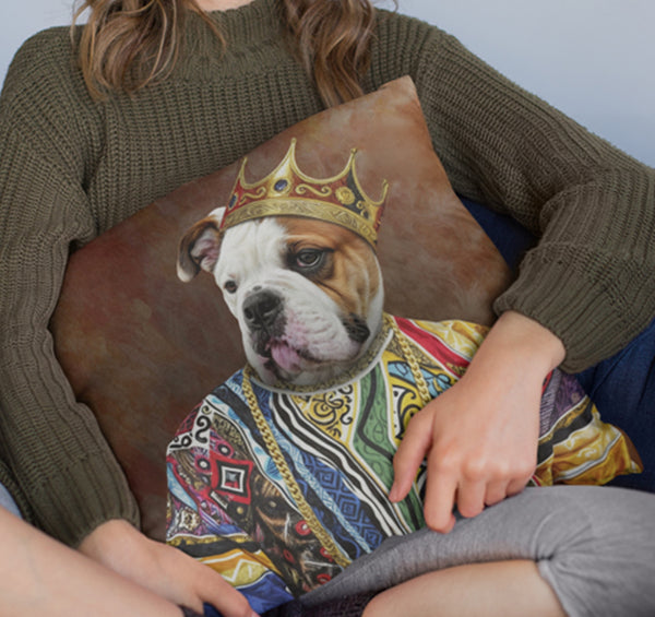 A person in a green sweater holds the Custom Notorious D.O.G Pet Cushion, which showcases a bulldog illustration in a colorful royal robe and gold crown—an ideal gift for pet lovers.
