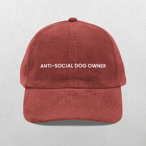 The Chord Vintage Cap - Anti Social Dog Owner features ANTI-SOCIAL DOG OWNER embroidered in white on the front, shown in burgundy corduroy against a light gray background—a fun gift for dog dads or anyone with humor.