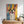 The Abstract Masterpiece - Custom Pet Portrait features a vibrant depiction of a happy dog with floppy ears on a wooden dresser, accented by woven and ceramic planters—an ideal pet lover gift for bright, sunlit spaces.