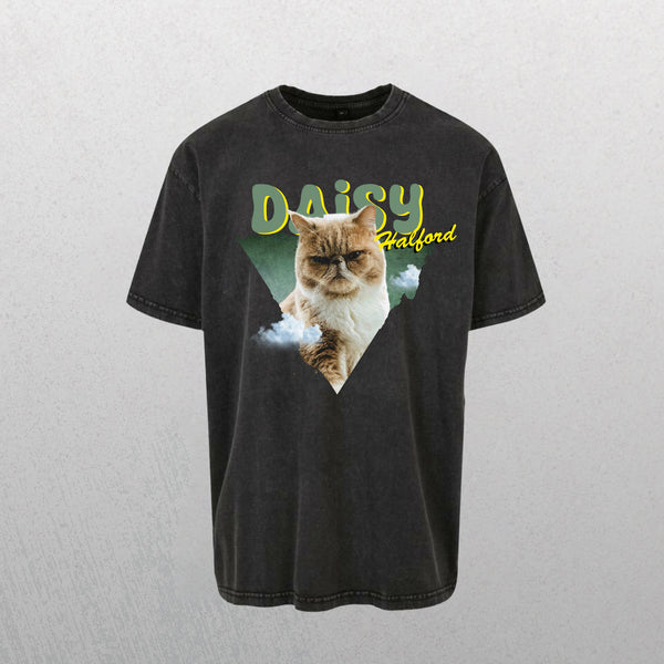 A grey Personalised Retro Tee | Green with a grumpy cat inside a green triangle, stylized yellow “DAISY” text above, “Halford” on the side, and cloud graphics near the triangle’s bottom.