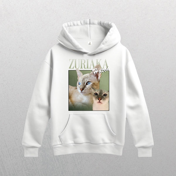 The white Personalised Homage Hoodie | Jungle features premium fleece and a graphic of two cats with blue and green eyes against muted green, plus ZURIAKA above and Hatch in script. Unisex fit.