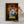 A person hangs the Jurassic Bark Pet Portrait, a framed poster with a white dog named Kurama, styled like a Jurassic Park movie poster with sunset, trees, and logo—perfect pet lover gift or home artwork.
