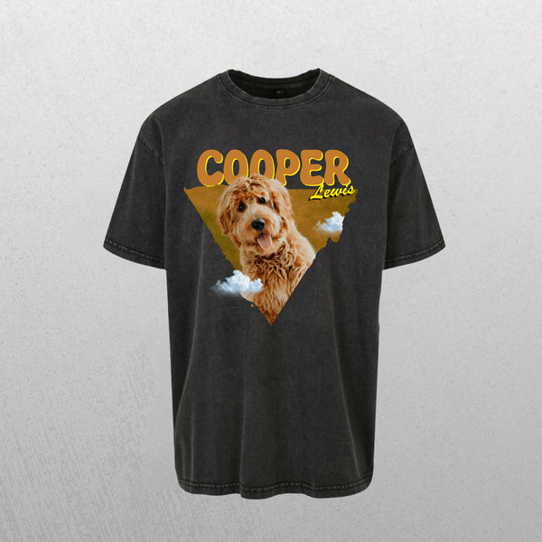 A grey Personalised Retro Tee | Orange featuring a graphic of a brown, fluffy dog with COOPER Lewis in large yellow letters above, set against a triangular yellow background with small clouds—perfect for pet lovers.