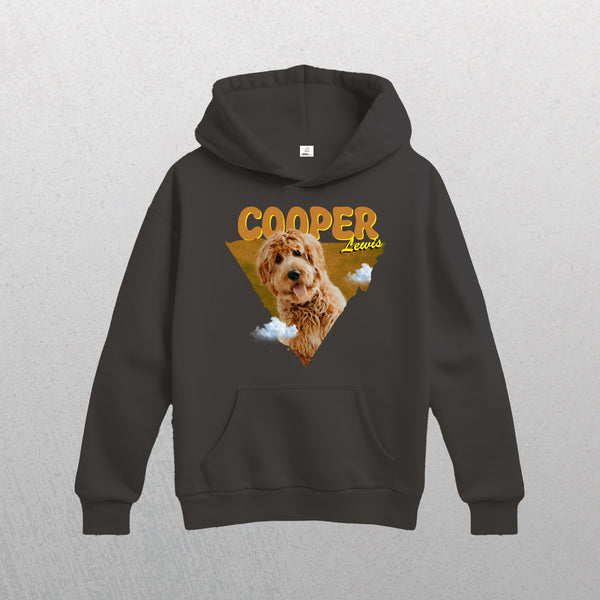 This grey Personalised Retro Hoodie | Orange showcases a brown, curly-haired dog with clouds and a yellow triangle backdrop. COOPER Lewis appears in bold yellow above, making it a cozy keepsake for any dog lover.