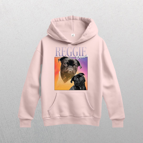 Light pink Personalised Homage Hoodie | Cosmic, featuring two illustrated pugs on a colorful square and REGGIE Breeds text above. Shown vintage-style on a light gray textured background.