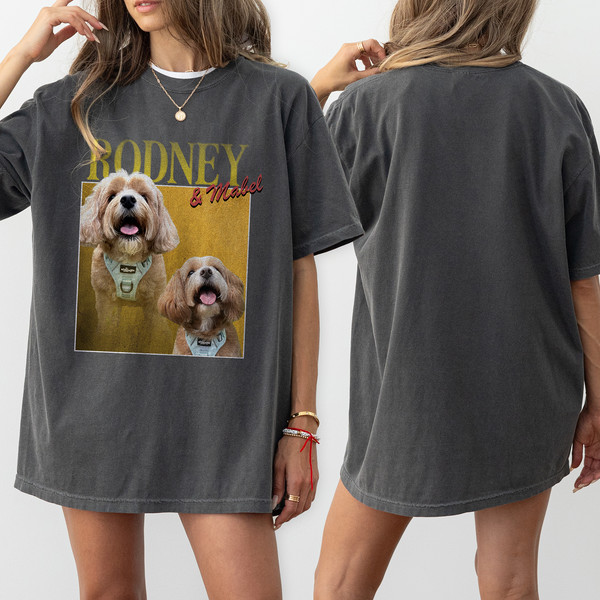 Two women wear oversized dark gray Personalised Homage Tee | Gold shirts; the front shows two fluffy dogs with RODNEY & Mabel—a custom dog shirt ideal for pet lovers. One woman faces forward displaying the graphic, the other shows the plain back.