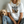 A woman wears a white Milf vintage pet t-shirt with Man I Love Felines and six cat images, sitting next to a fluffy dog—perfect gift for pet lovers.