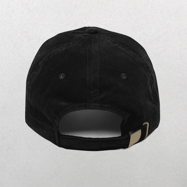 The Chord Vintage Cap - Dogs Before Dudes is a black corduroy baseball cap with an adjustable metal buckle strap, shown from the back on a light gray background—ideal for dog lovers wanting a stylish embroidered dog cap.