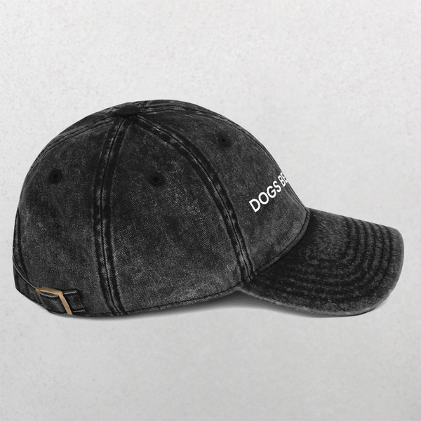 A black, distressed Vintage Cap - Dogs Before Dudes with white DOGS BE embroidery on the front, displayed against a plain light gray background.