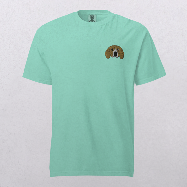 The Embroidered Pet Portrait Organic T-Shirt in light teal features a small brown and white dog face embroidered on the left chest, displayed on a plain background—an ideal gift for pet lovers.