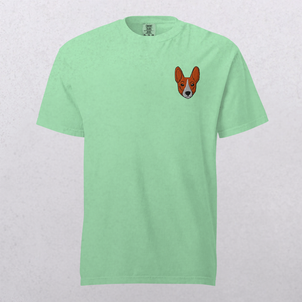The Embroidered Pet Portrait Organic T-Shirt in light green features a small corgi-like dog face embroidered on the left chest. Ideal for pet lovers, this funny tee is shown on a simple, light background.