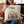 A woman smiles while holding a Custom Cartoon Pet Cushion—a beige pillow featuring an illustrated dog’s face and the name Max above it.