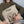 A person in a green sweater holds a Custom Cartoon Pet Cushion with an illustrated dog’s face and the name Max above it. This cozy keepsake is the perfect gift for pet lovers. The person’s face is not visible.