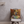 The Custom Notorious D.O.G Pet Cushion displays a German Shepherd in a colorful sweater and gold crown on a brown background. Placed on a chair with light walls and a white shelf, its the perfect custom accent for any pet lover’s room.