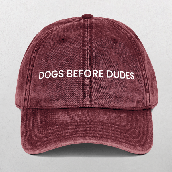 Show your pet-loving pride with the Vintage Cap - Dogs Before Dudes in maroon, featuring a worn texture and white embroidered DOGS BEFORE DUDES text on the front—a fun cap for any dog mom.