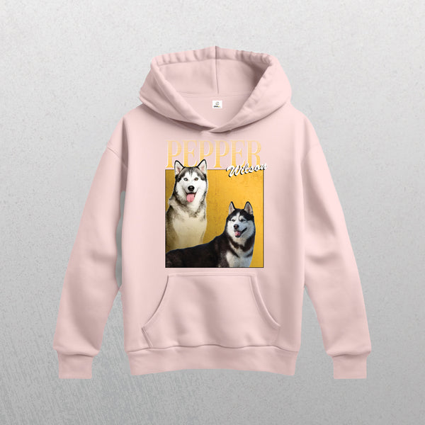 The Personalised Homage Hoodie | Gold in light pink features a graphic of two huskies, PEPPER and Wilson in bold white and script fonts on a yellow background—a cozy keepsake for husky lovers.