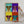 A person in a white sleeve holds the Warhole Custom Pop Art, a framed pet artwork featuring a dog in four vibrant quadrants with teal, purple, yellow, and red backgrounds.