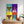 A Warhole Custom Pop Art—four vibrant dog portraits in pop art style with unique backgrounds—hangs above a wooden dresser with a plant and basket, making it the perfect gift for pet lovers.