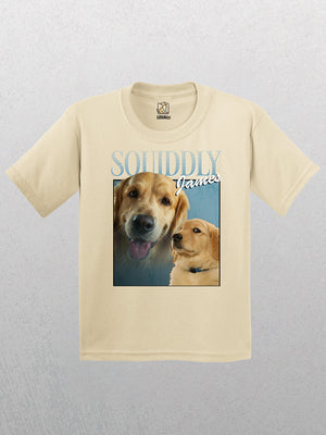 The Personalised Homage Tee - Ice (Kids) is a beige heavyweight shirt with two golden retrievers—one facing forward, one looking up—in soft Airlume ring spun cotton, with “SOUNDLY James” in bold, stylized letters above them.